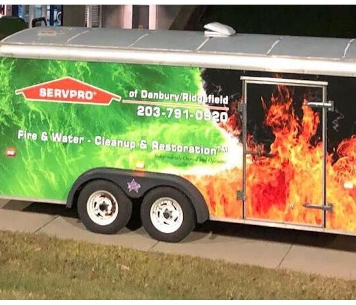 A SERVPRO enclosed trailer parked in a driveway. 